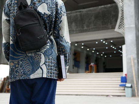 A student with a backpack standing in front of a university building.