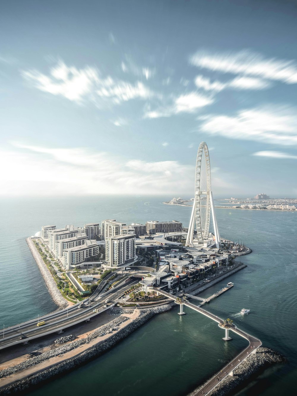 an aerial view of a ferris wheel in the middle of the ocean