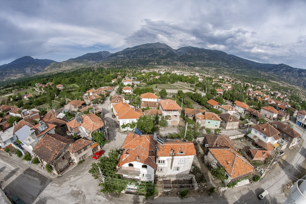 a bird's eye view of a village with mountains in the background