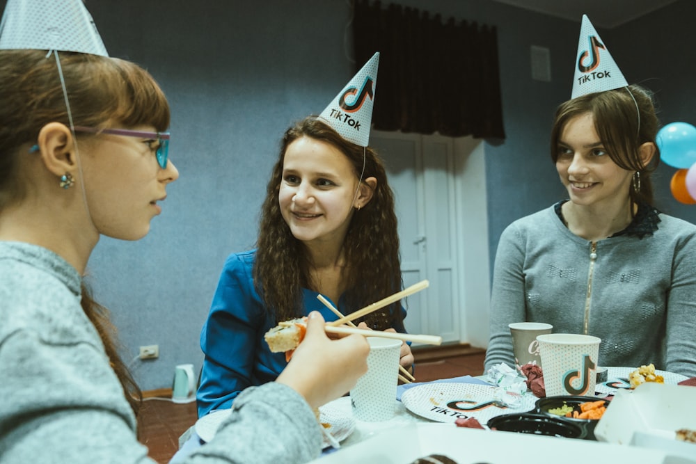 a group of young women sitting around a table