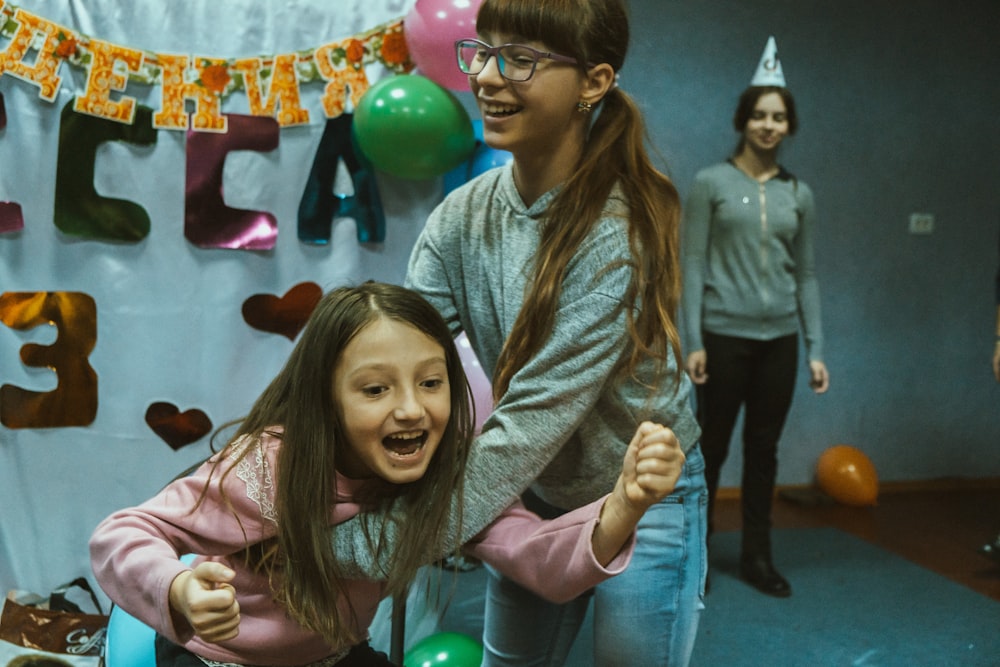 a young girl with a birthday hat on her head