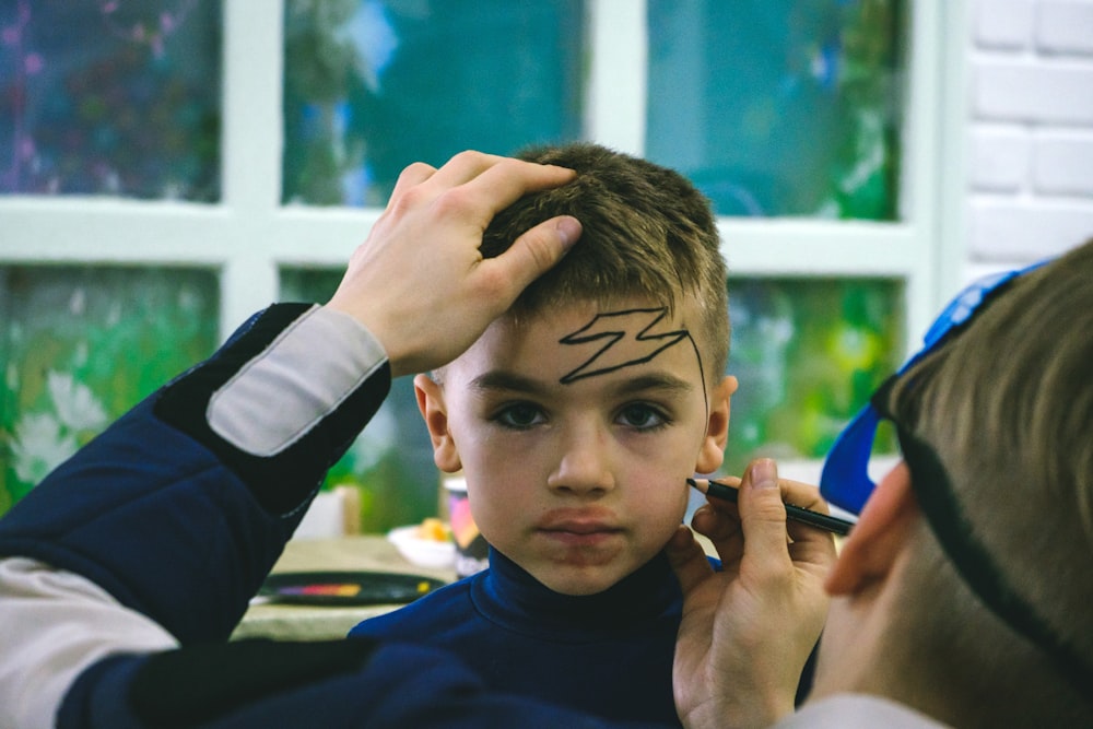 a young boy is getting his hair cut