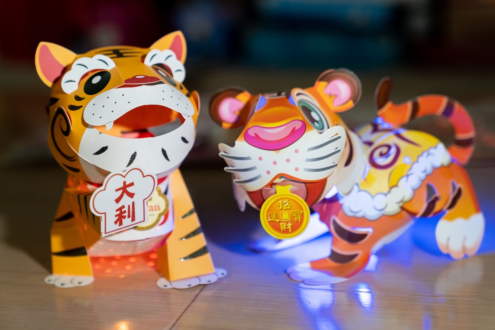 two paper tiger figurines sitting on a table