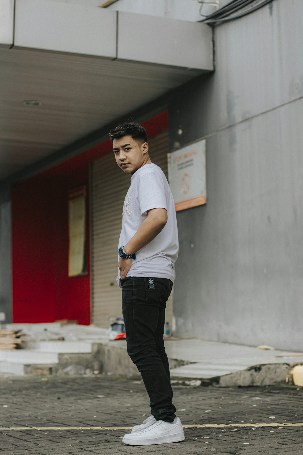 a young man standing in front of a building