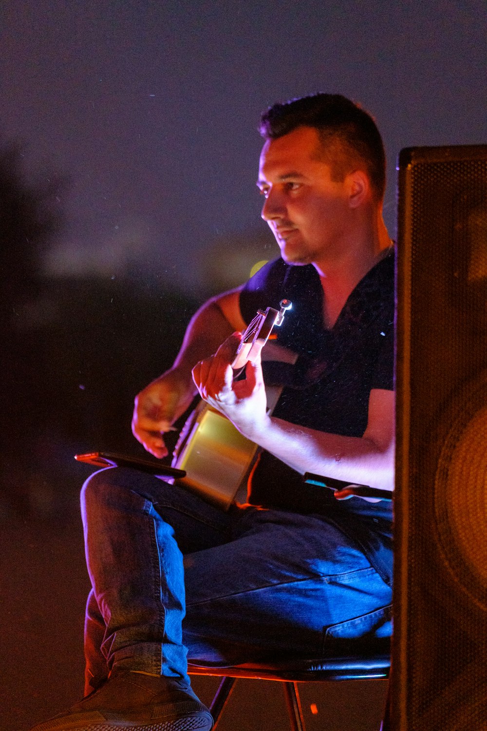 a man sitting on a chair holding a bottle of wine