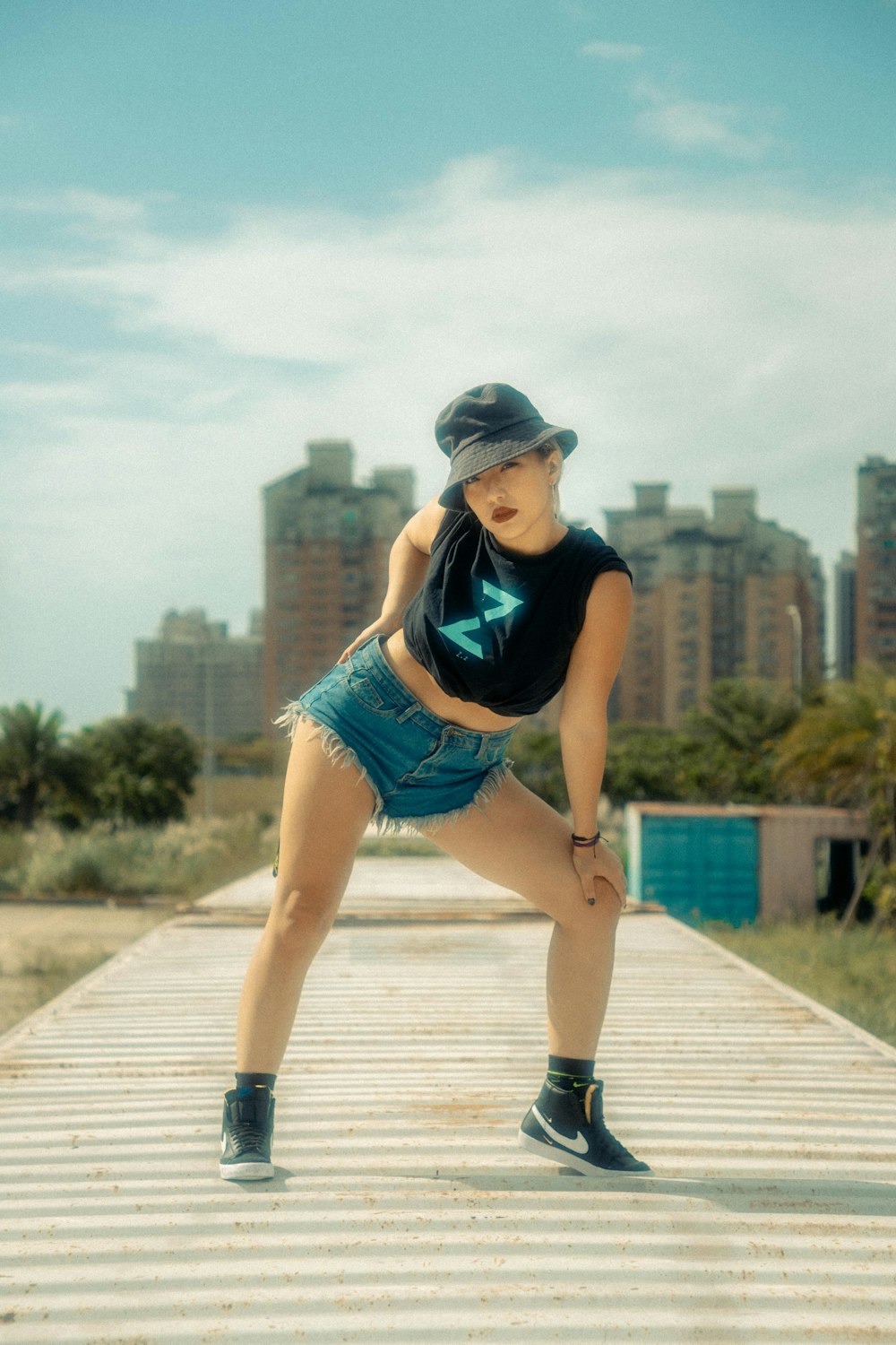 a woman in short shorts and a hat posing for a picture