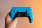 a person holding a blue video game controller