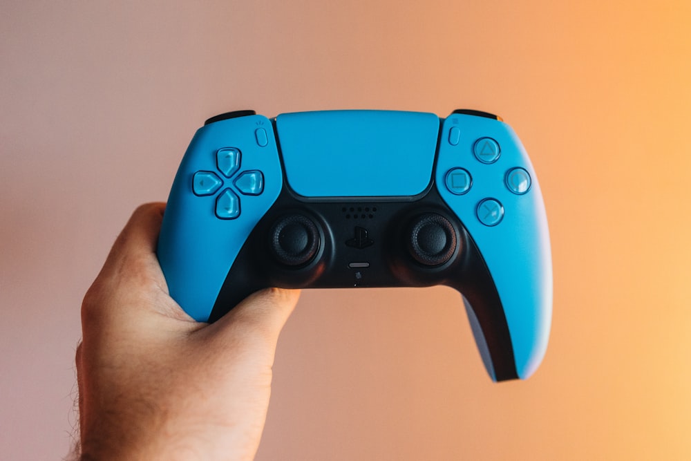 a person holding a blue video game controller