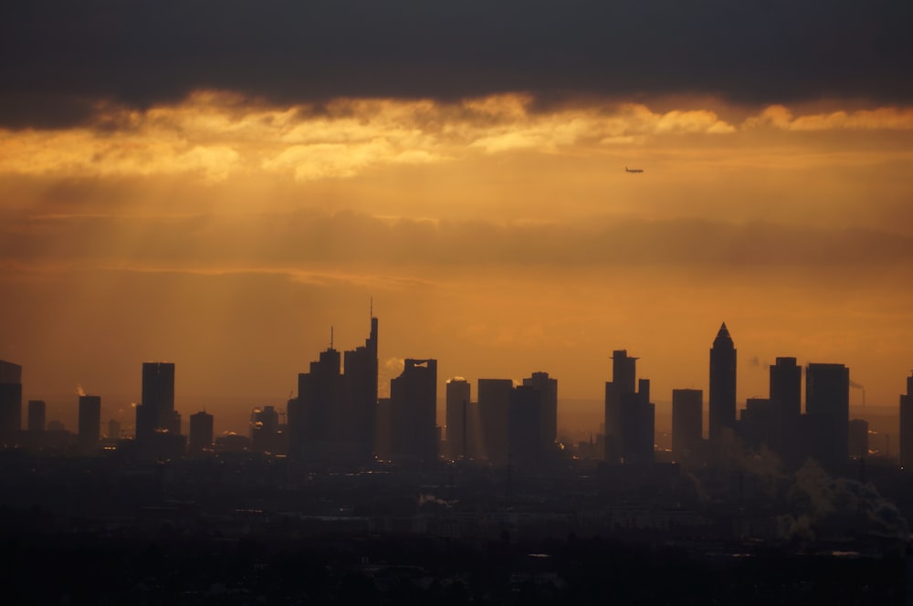 a plane flying over a city at sunset