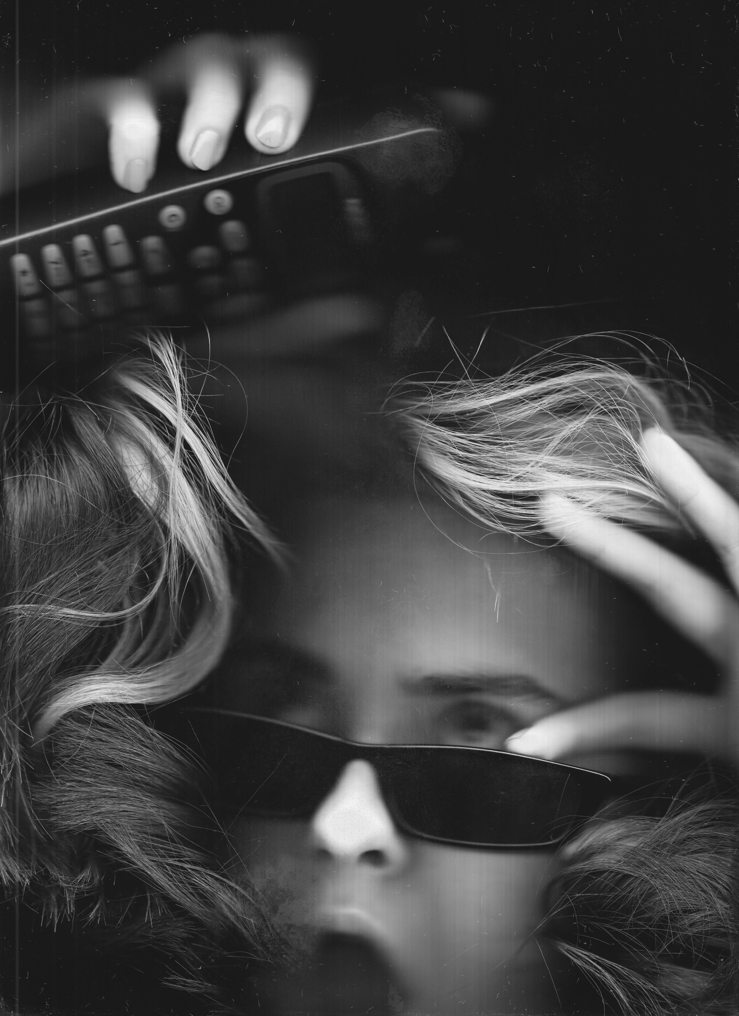 a black and white photo of a woman holding a remote control