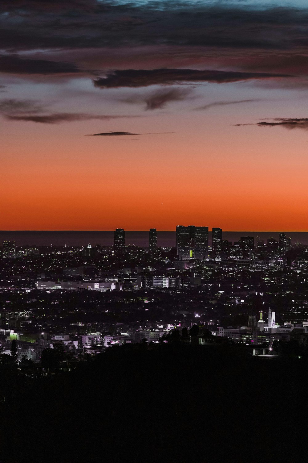 a view of a city at night from a hill