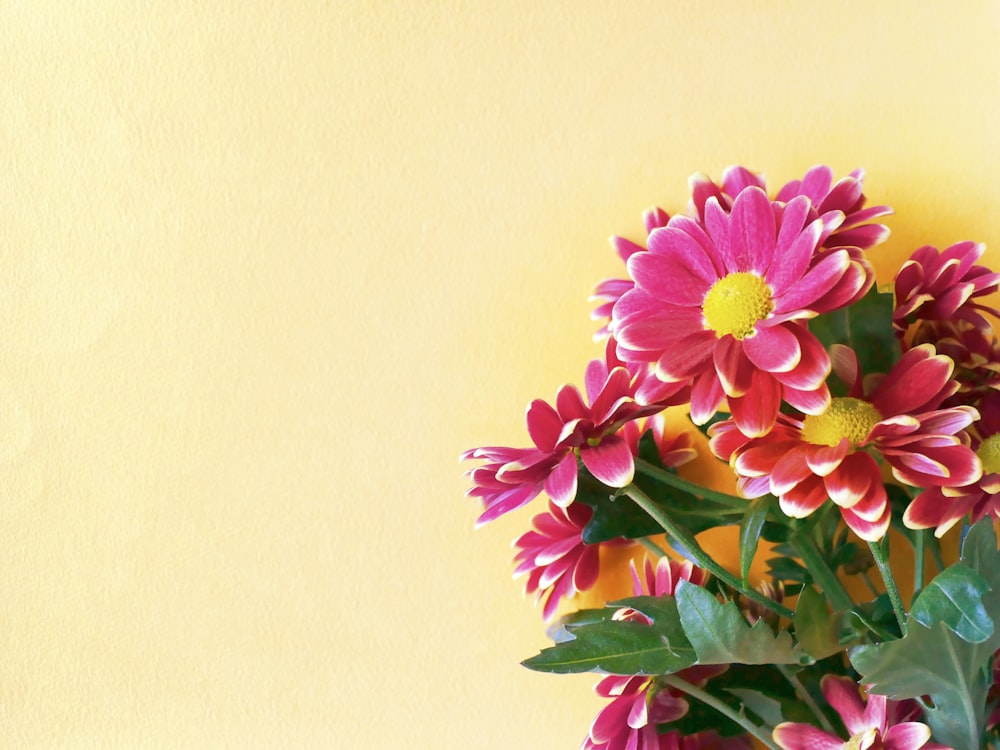 un vaso pieno di fiori rosa e gialli