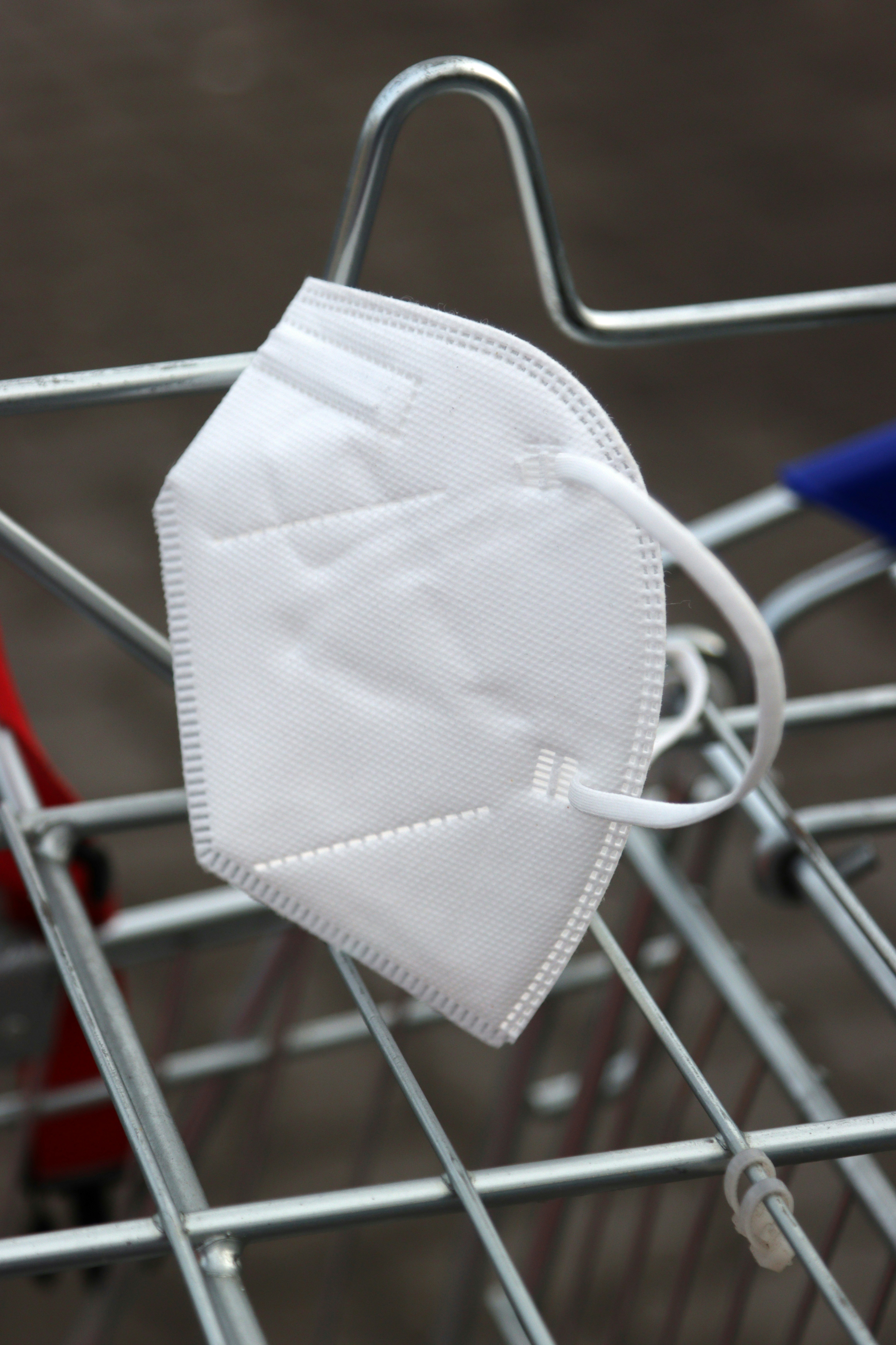 un masque facial blanc assis sur le dessus d’un panier d’achat