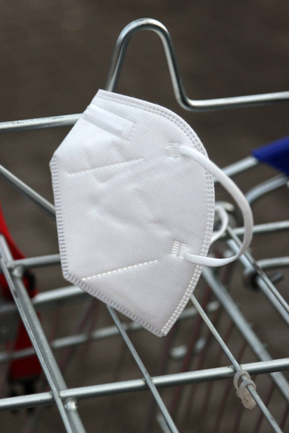 a white face mask sitting on top of a shopping cart
