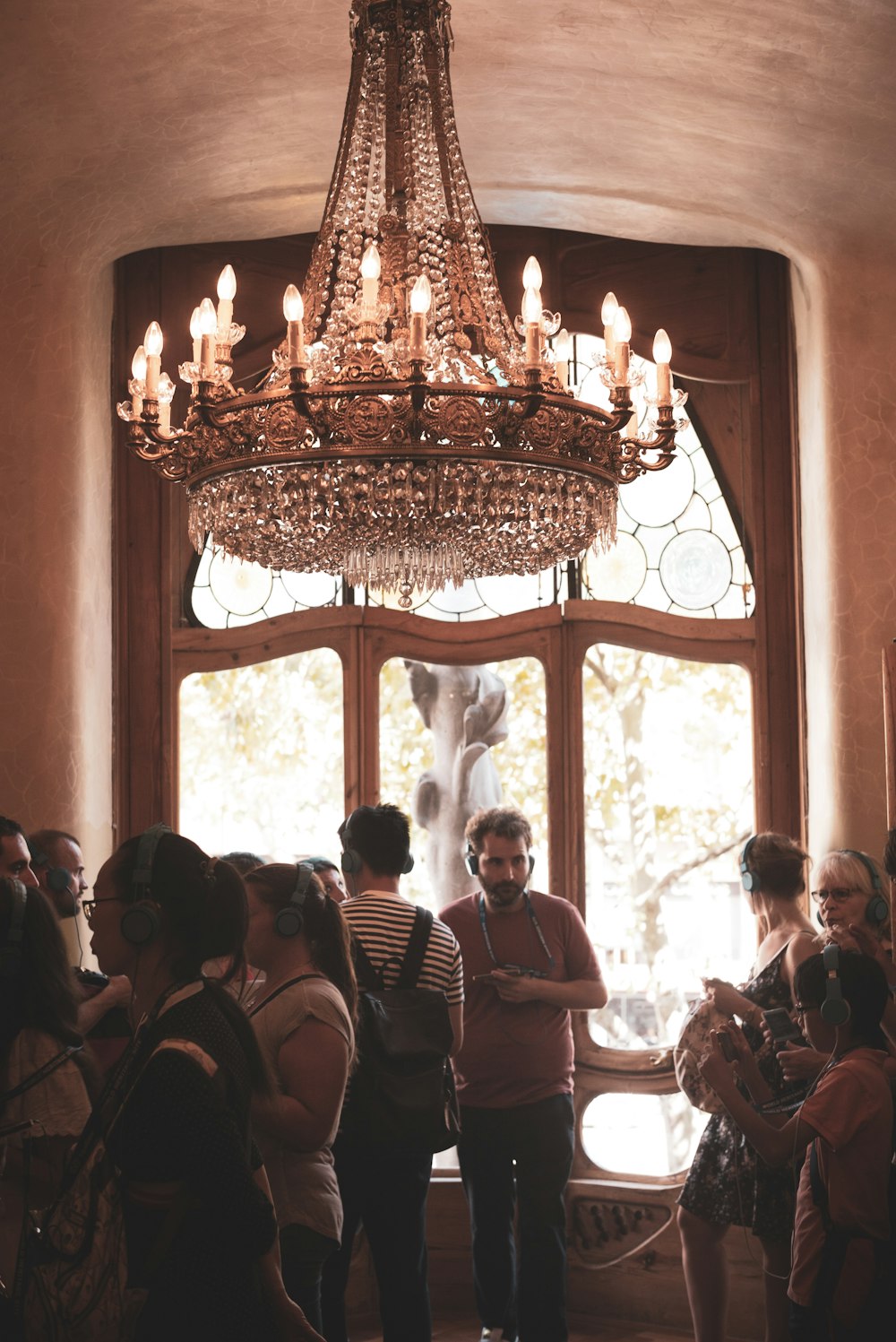 a group of people standing in front of a chandelier