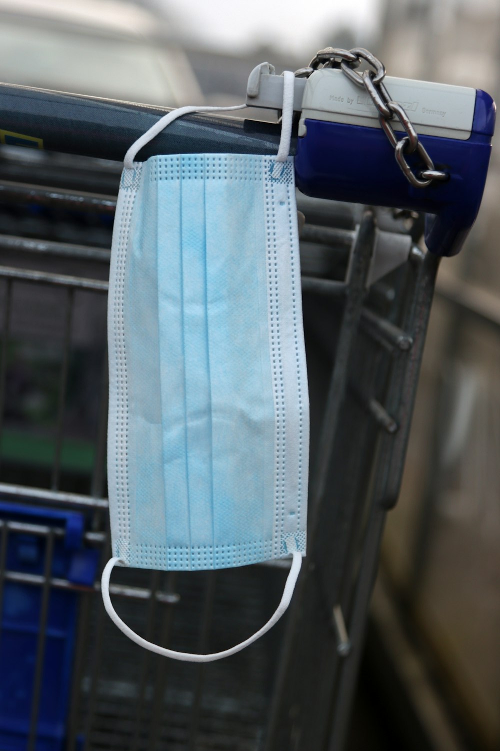 a face mask hanging from a shopping cart