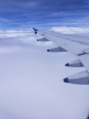 Modern aircraft soaring against a deep blue sky, symbolizing ambition and achievement.