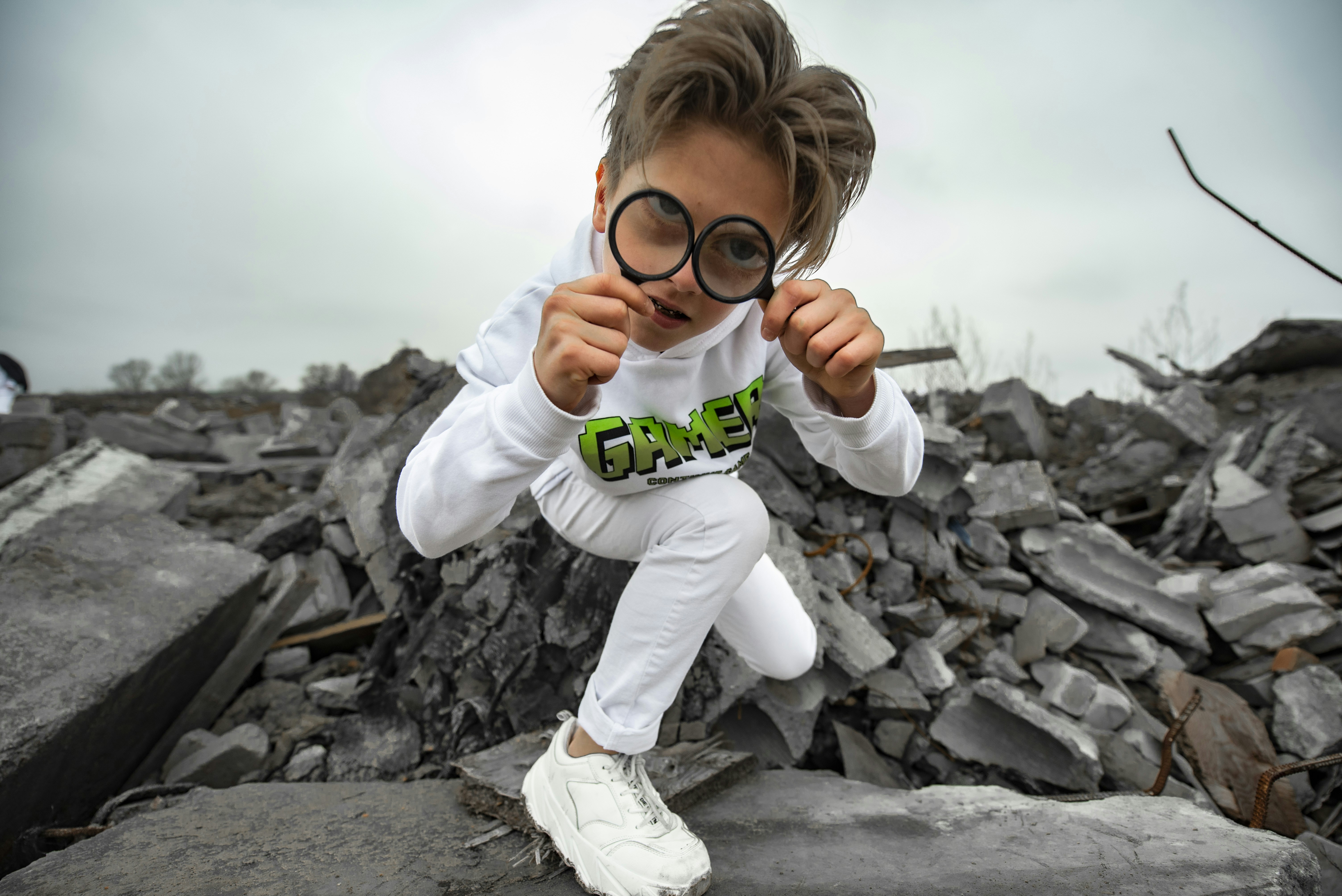 a young boy wearing a pair of glasses on top of a pile of rubble