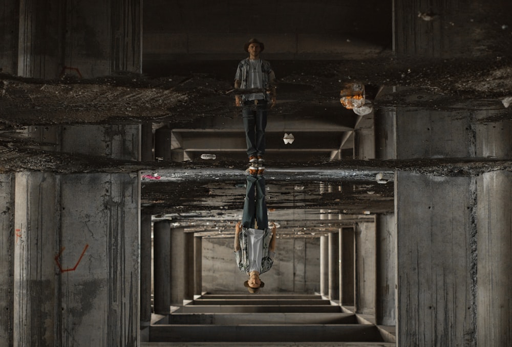 a man is walking through a tunnel with his reflection in the mirror