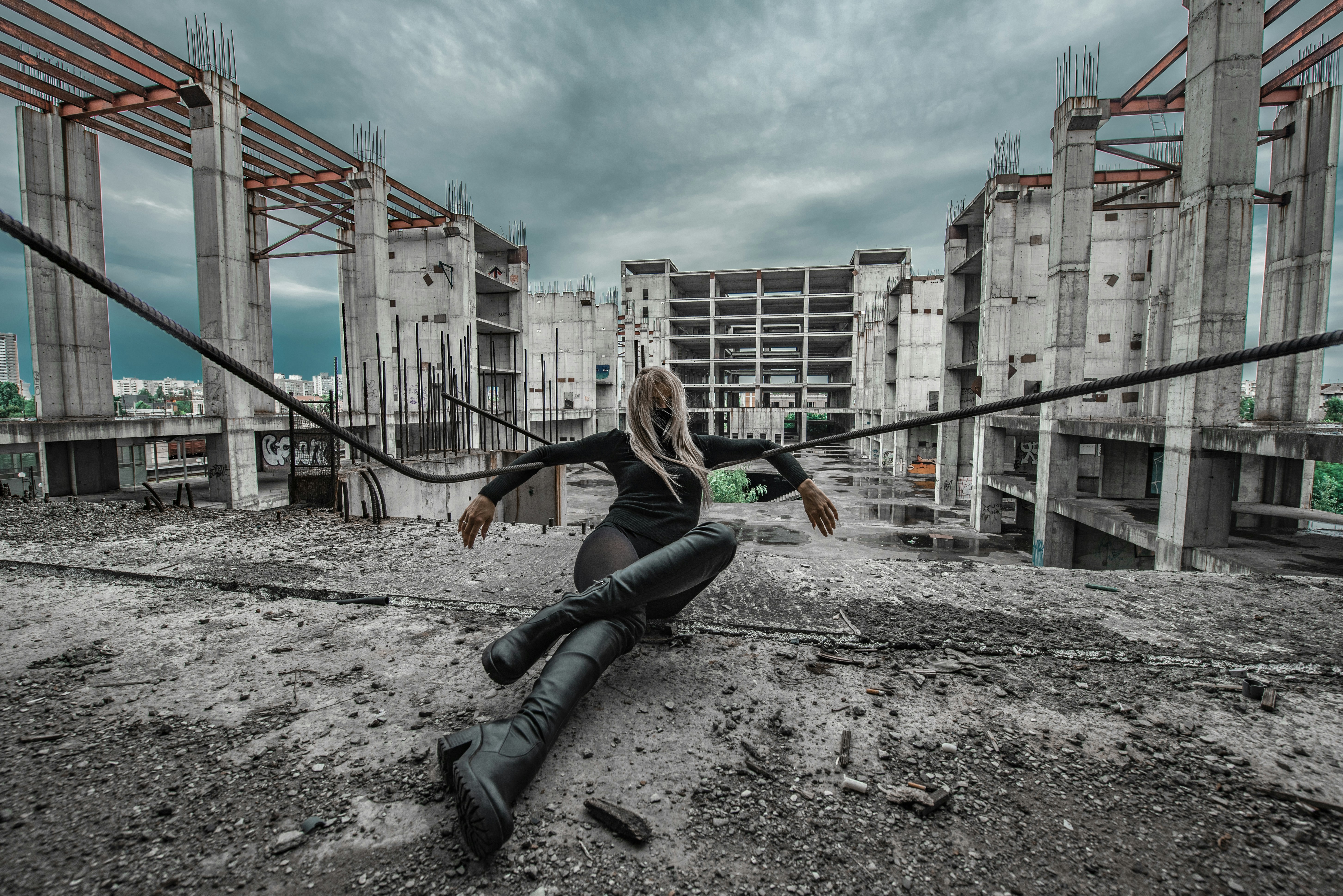 una donna seduta a terra di fronte a un edificio