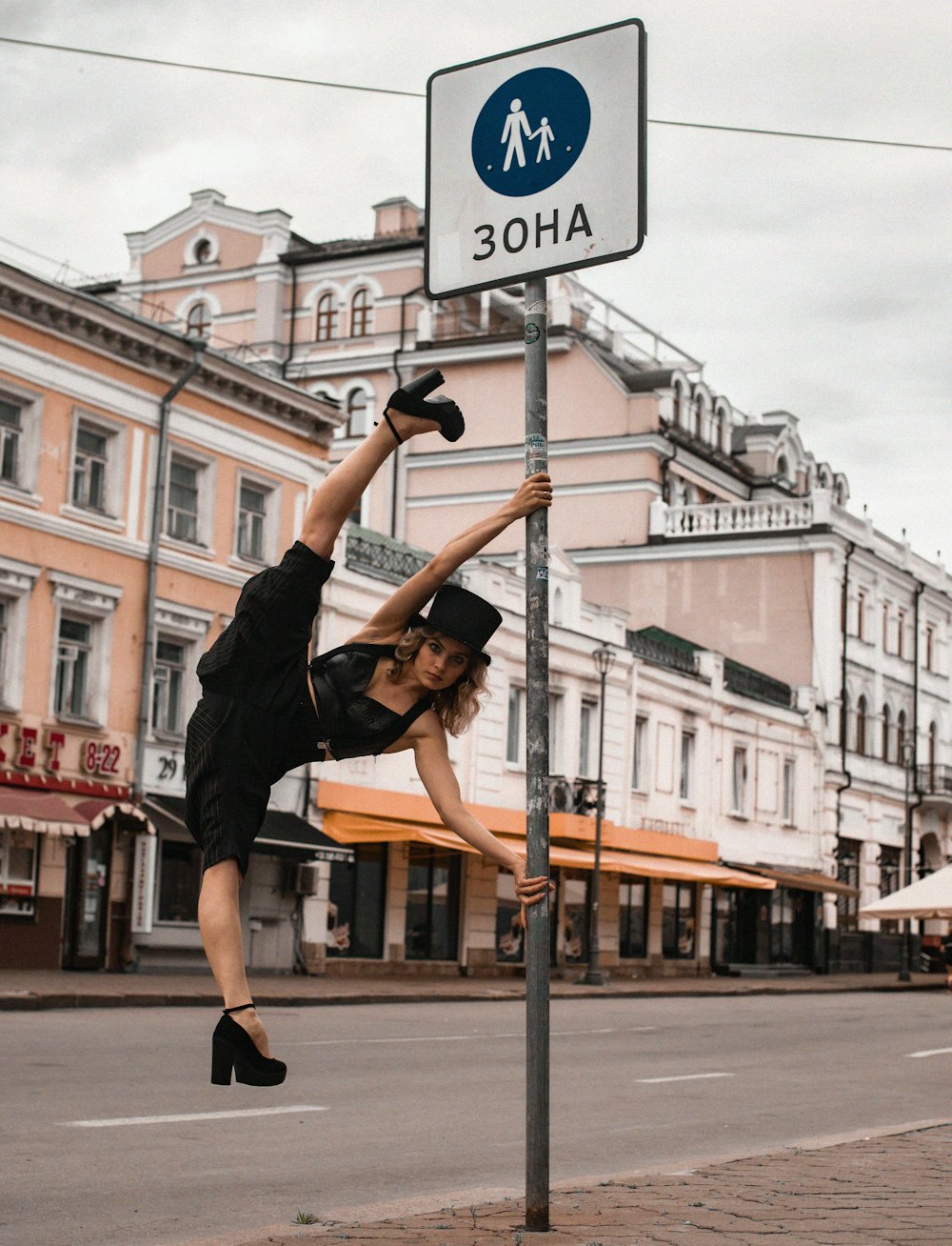 Eine Frau macht einen Handstand auf einem Straßenschild