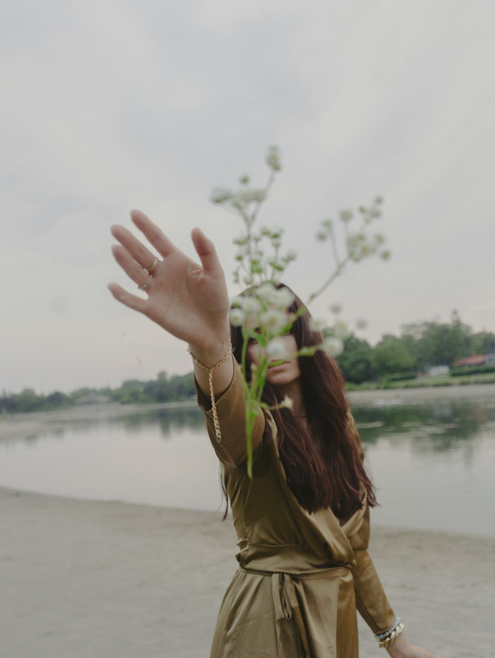 a woman standing on a beach next to a body of water