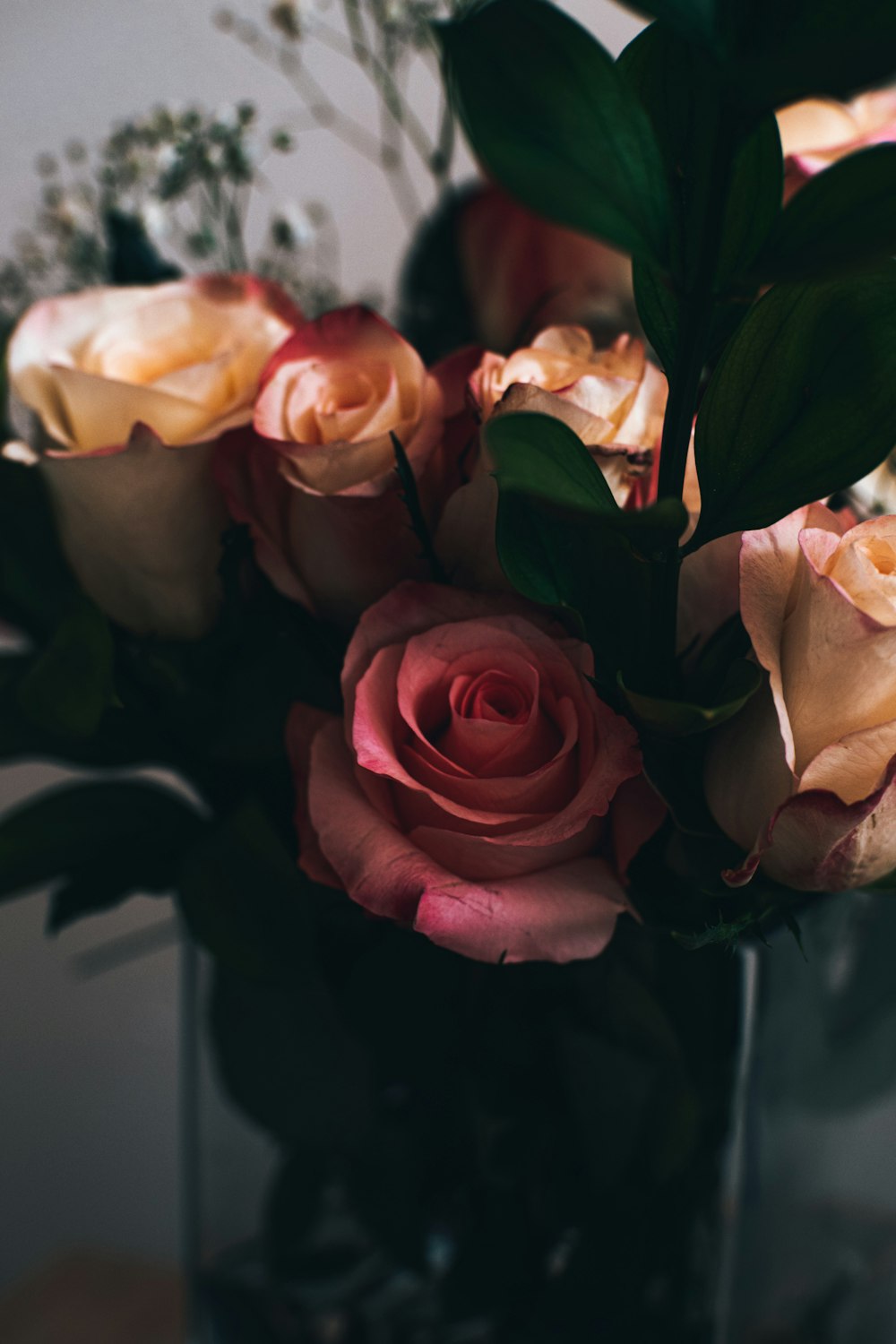 a vase filled with lots of pink roses