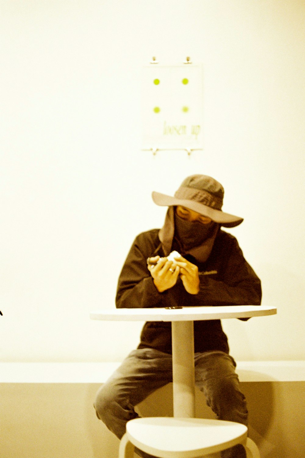 a person sitting at a table with a hat on