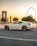 a white sports car parked in front of a ferris wheel