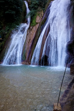 a man standing in front of a waterfall