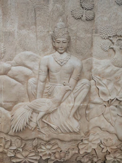 a statue of a person sitting on a rock