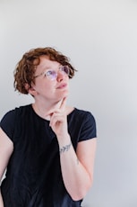 a woman wearing glasses and a black shirt