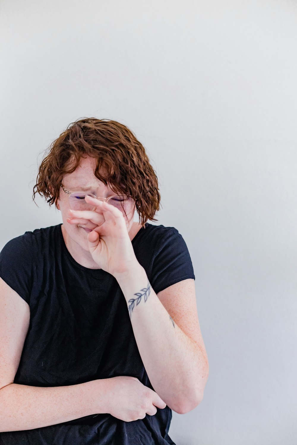 a woman sitting down with her hands on her face