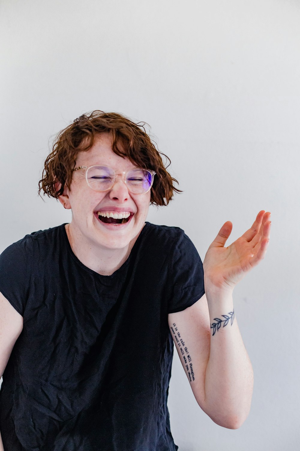 a man with glasses and a black shirt is laughing