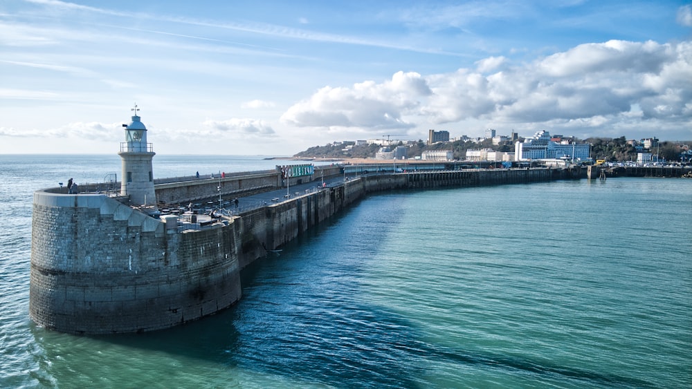 a light house sitting on top of a pier next to the ocean