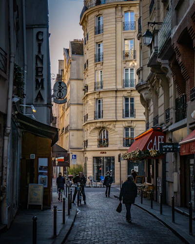 a group of people walking down a street next to tall buildings