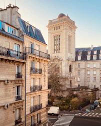 a tall building with a clock tower next to other buildings