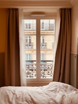 a bed sitting next to a window in a bedroom