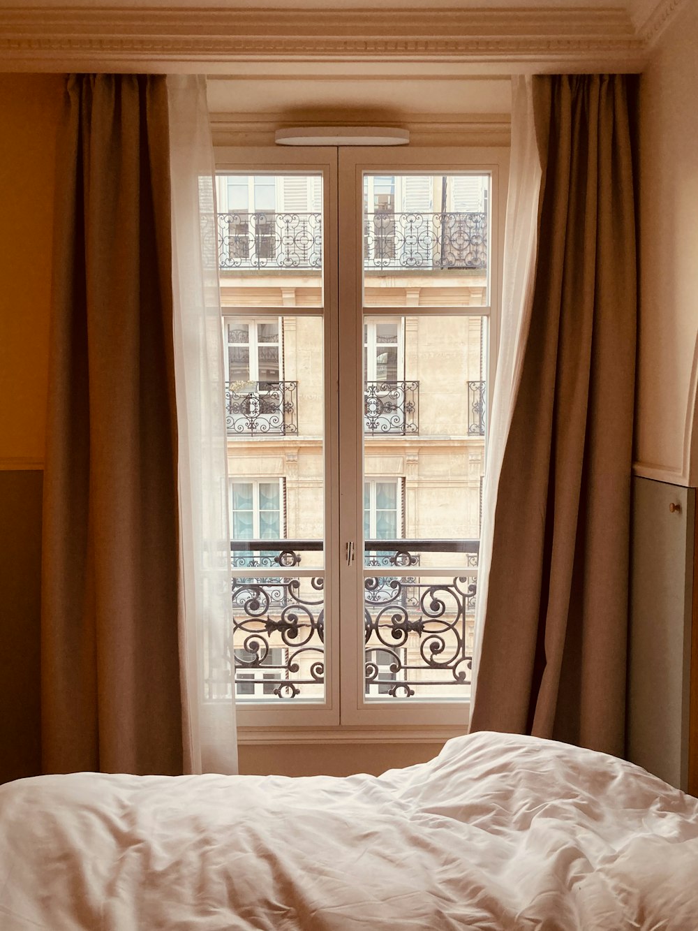 a bed sitting next to a window in a bedroom