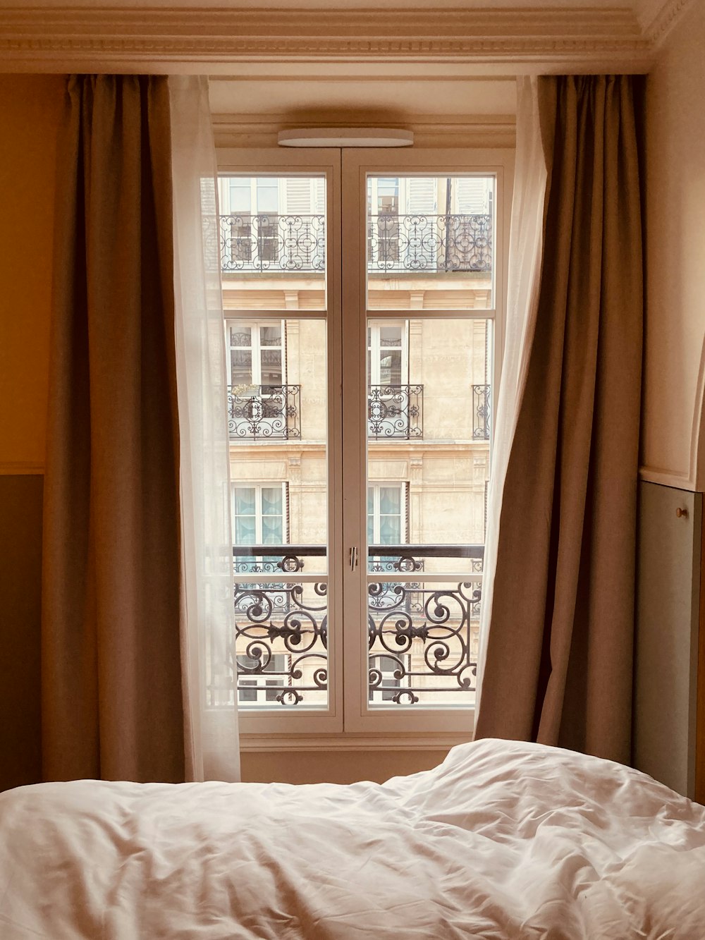 una cama sentada junto a una ventana en un dormitorio