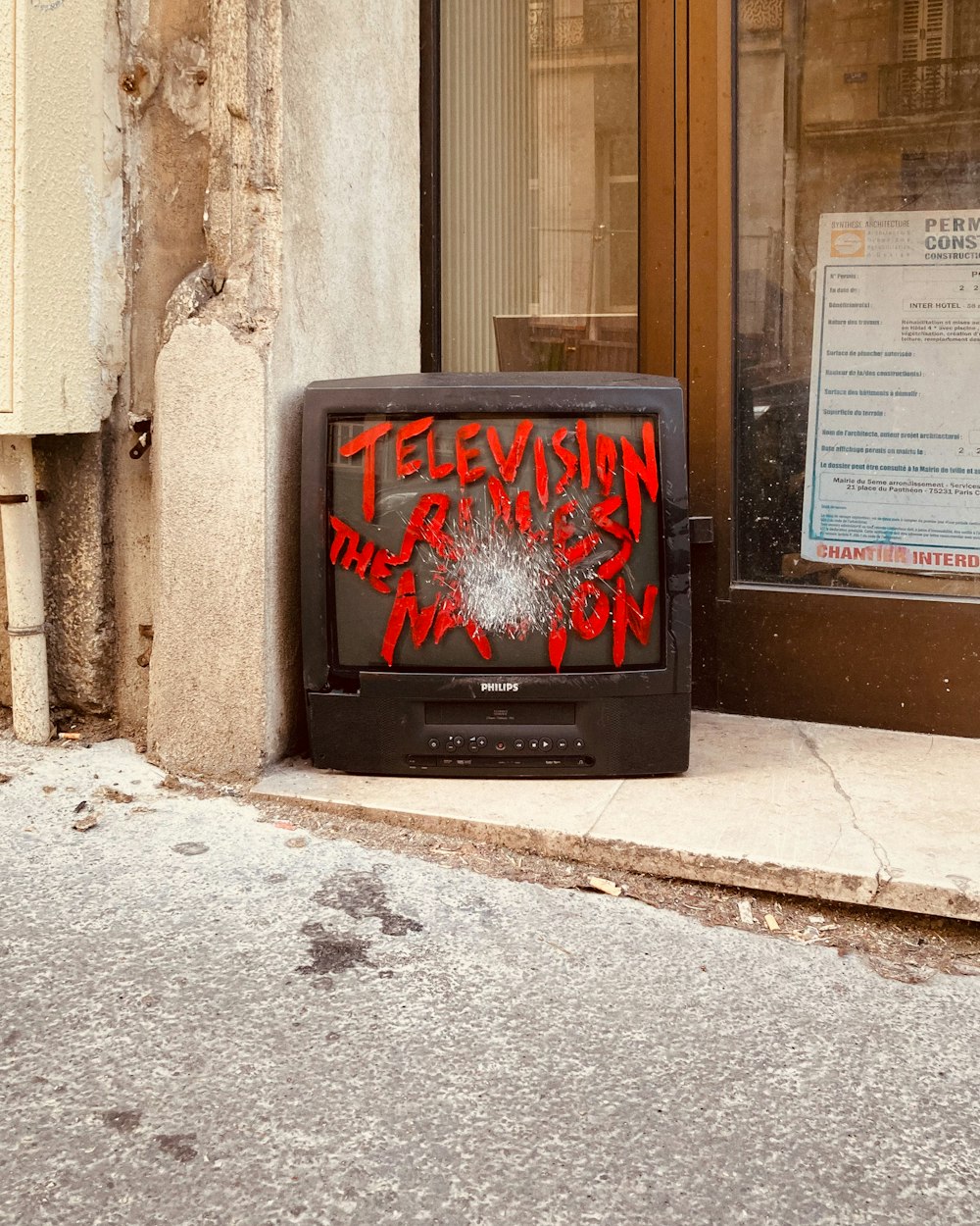 a television sitting on the side of a building