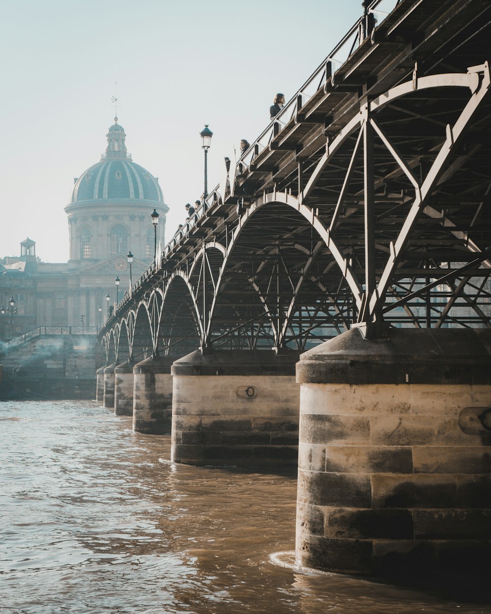 a bridge over a body of water with a building in the background