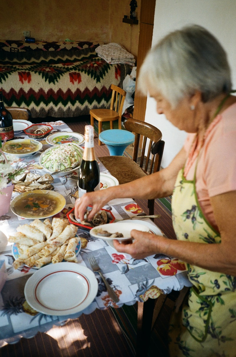 Older woman sitting at a table with a plate of food, reflecting on appetite changes after 65