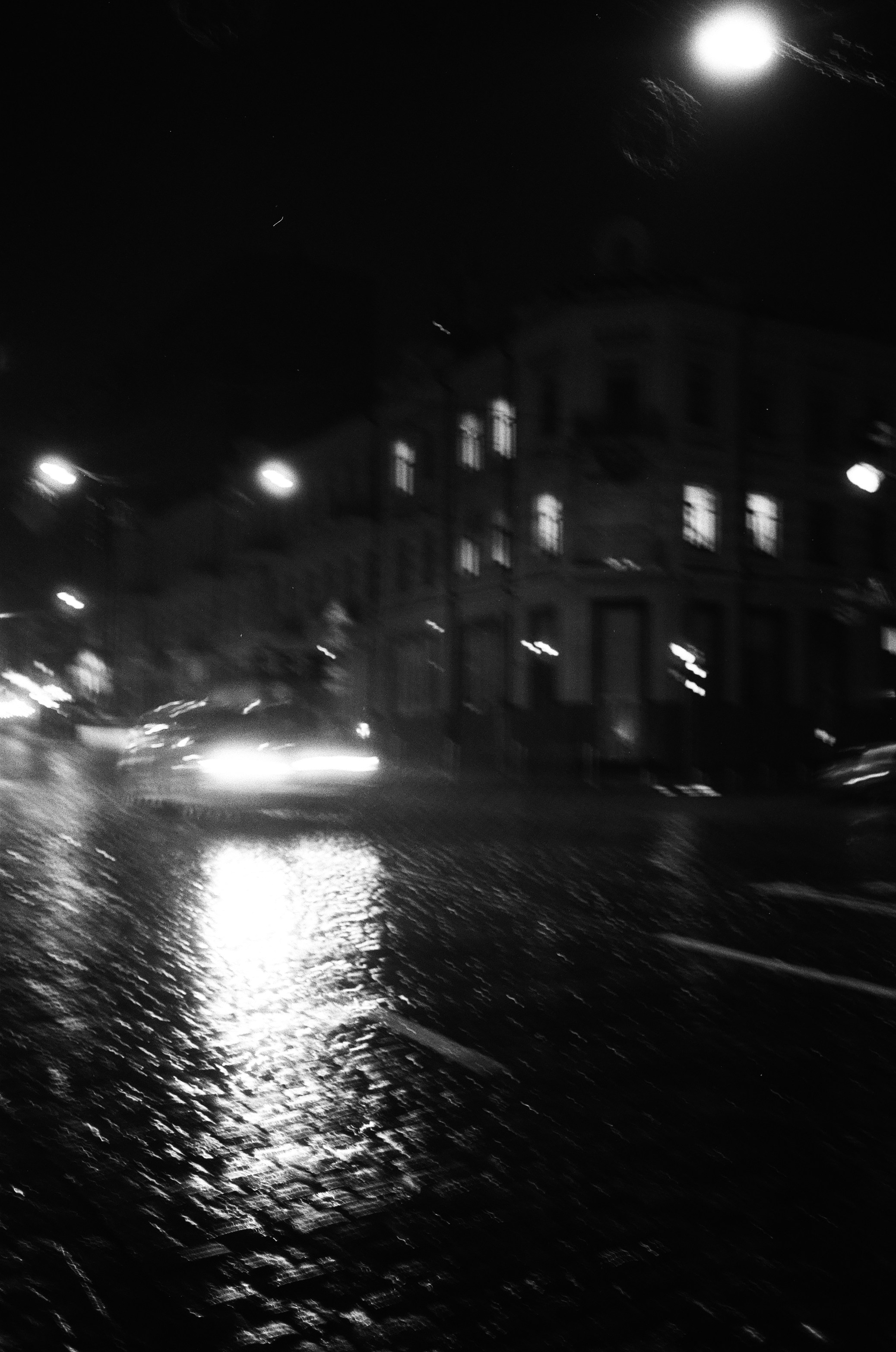 a black and white photo of a city street at night