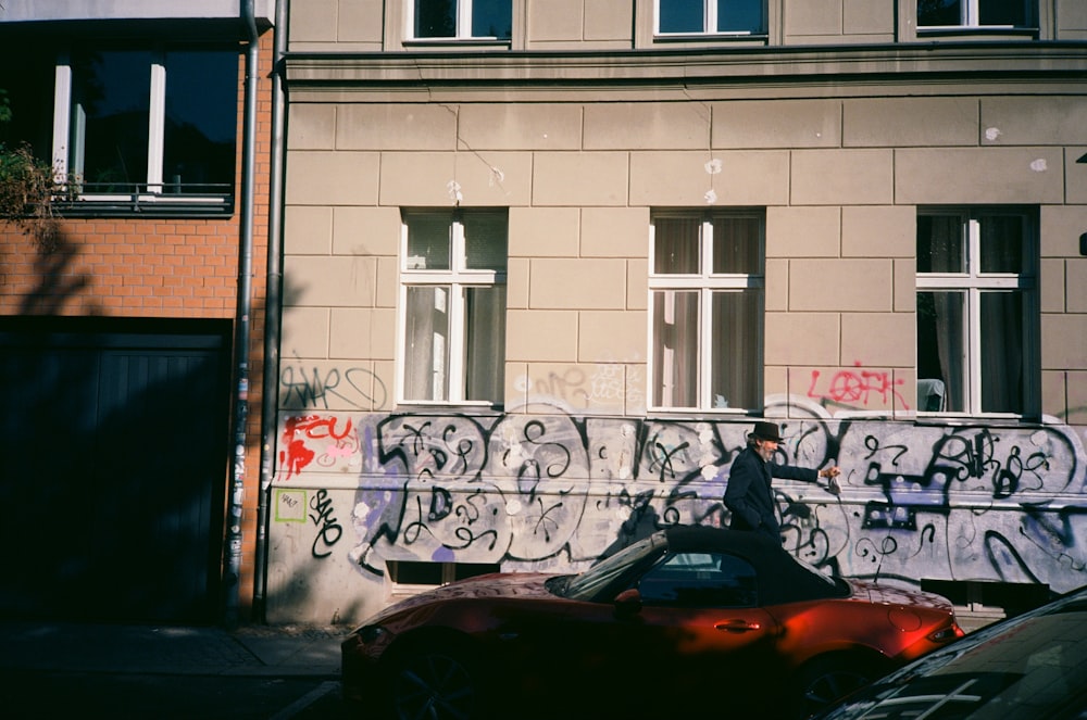 a car parked in front of a building covered in graffiti