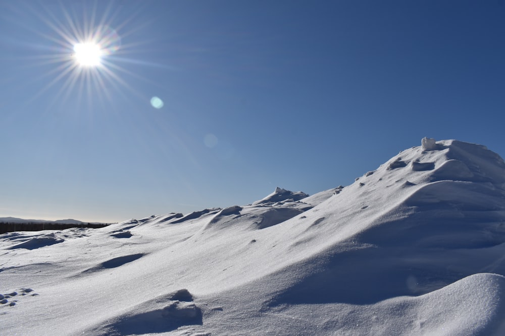 the sun is shining over a snowy mountain