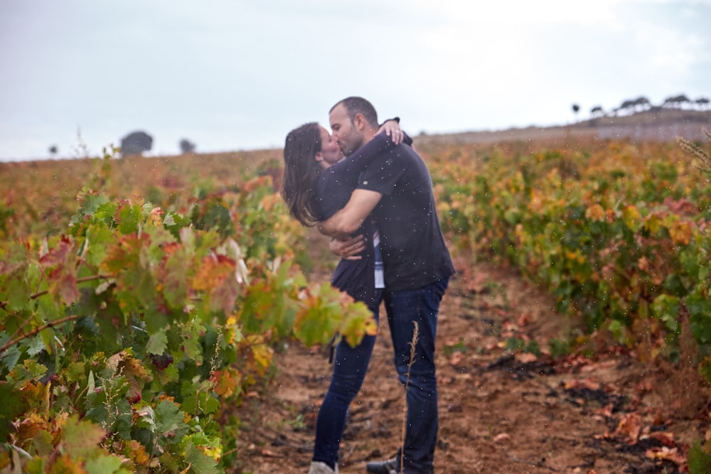 a man and a woman kissing in a field