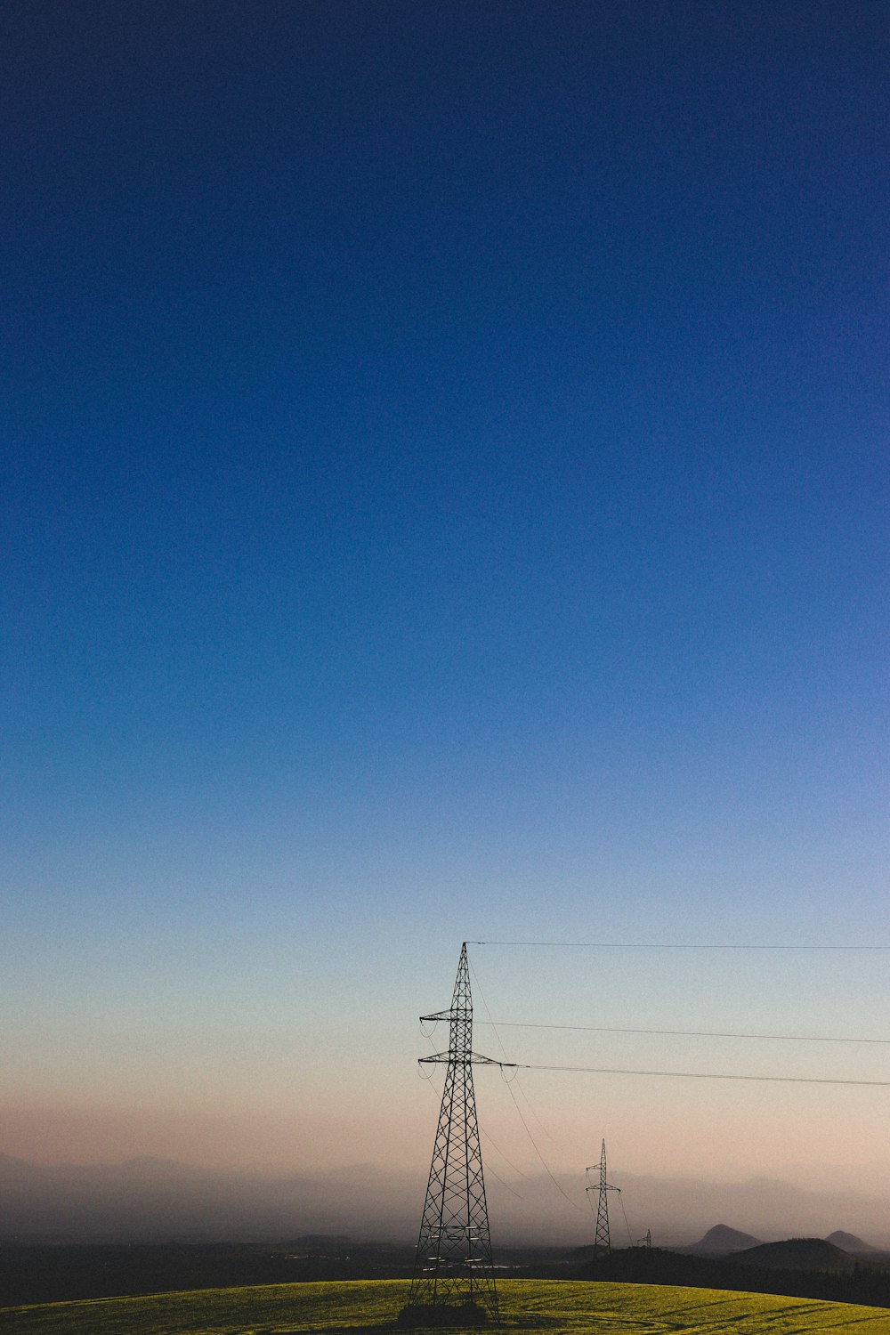 a field with a telephone pole in the distance