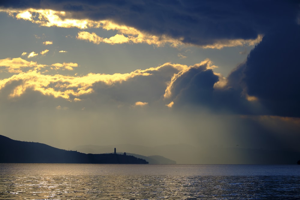 a large body of water under a cloudy sky