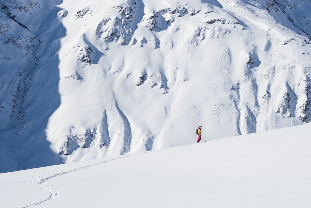 Eine Person, die einen schneebedeckten Berg hinunterfährt